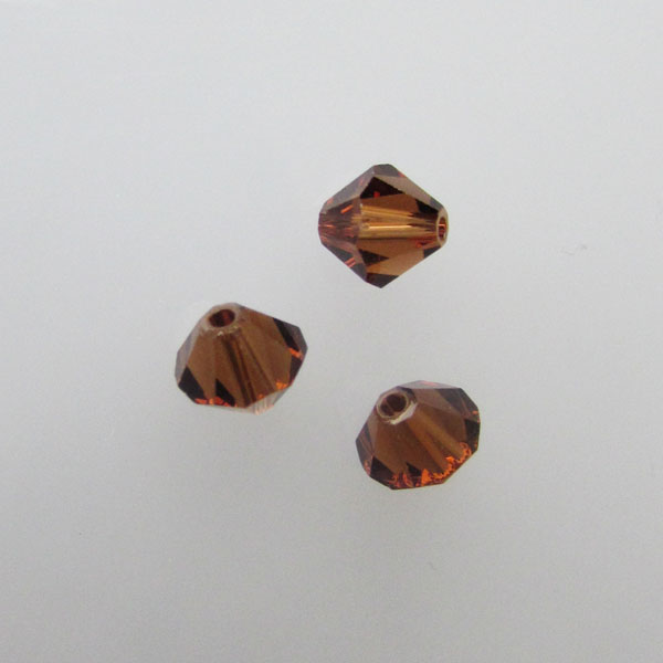 Swarovski® bicone, Xilion, 6 mm, SMOKED TOPAZ, verpakt p. 6 stuks